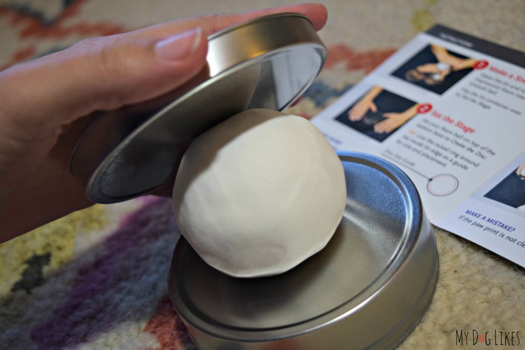 Using the top of the canister lid to flatten out the snowball. The rims around the edges prevent you from making the disc too large.